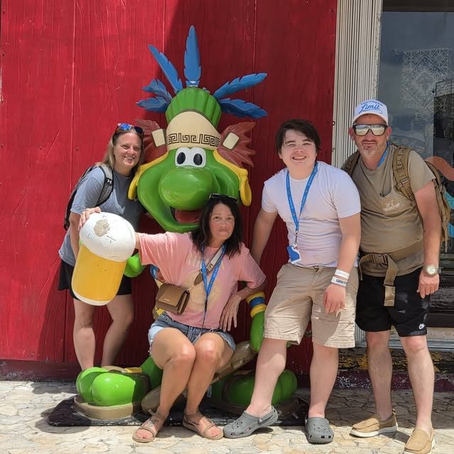 A family posing with a colorful statue in port