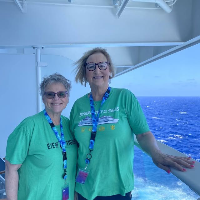 Two friends on a cruise ship balcony above the ocean