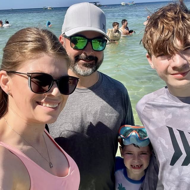 A family in clear shallow water on a beach day