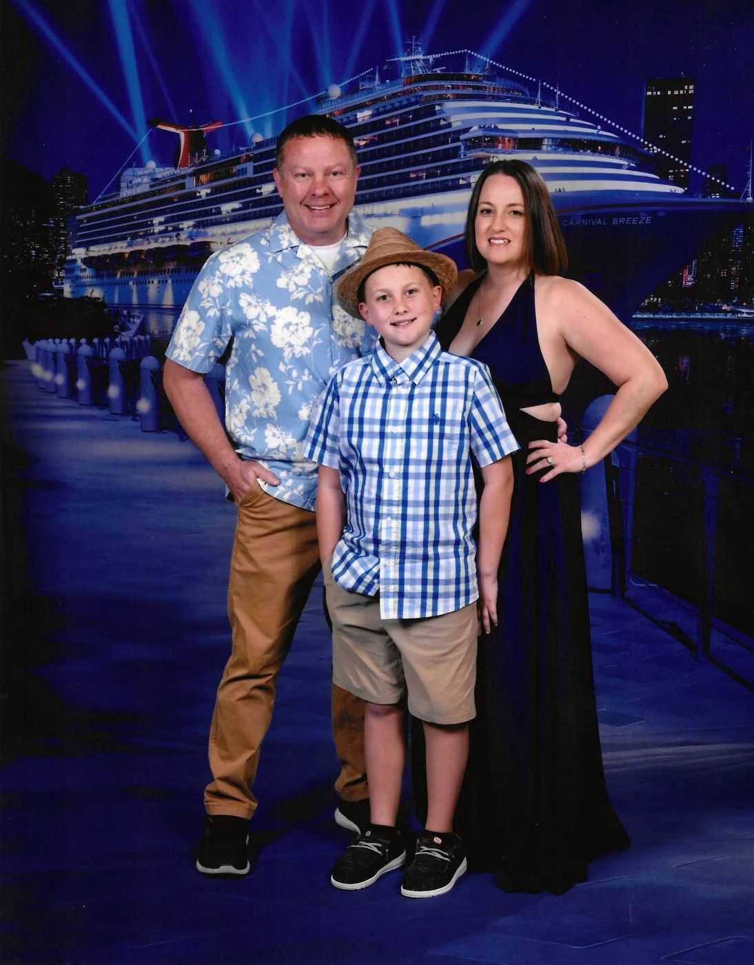 JD with his wife and son in front of a Carnival Breeze backdrop